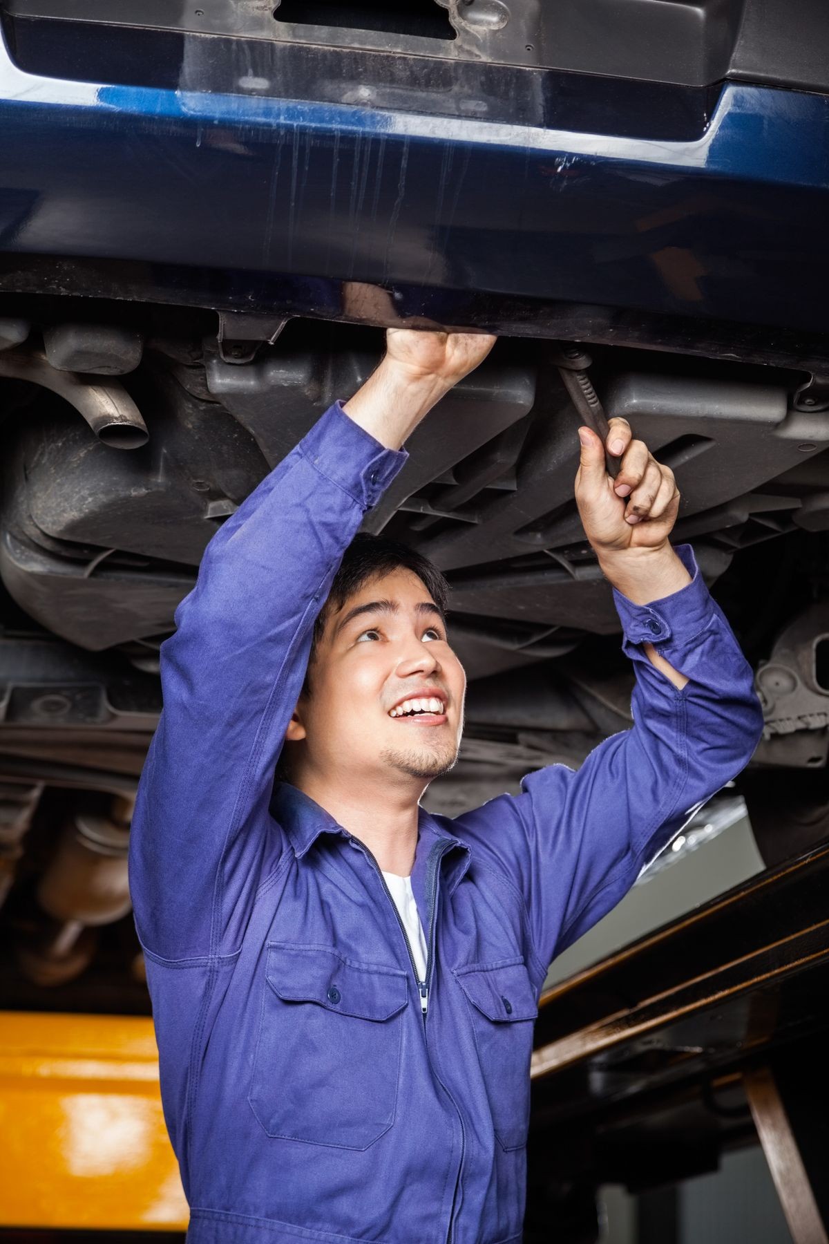 Mechanic Repairing Under Lifted Car